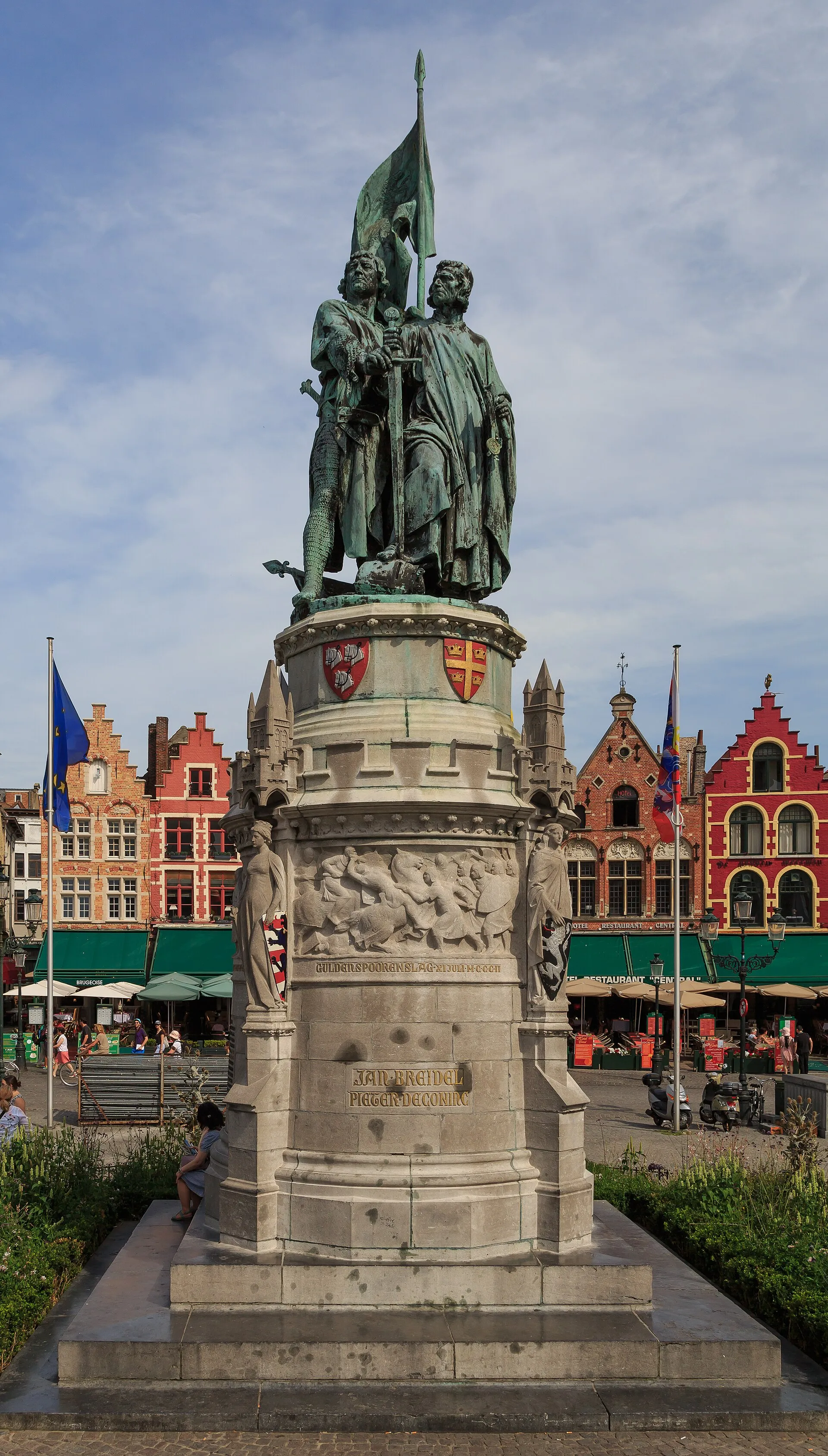 Bronze statue of two standing men in the middle of the Grote Markt.