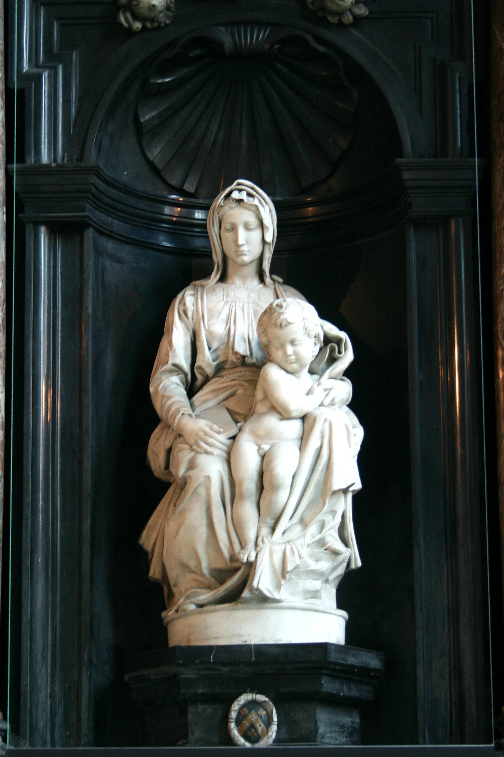 The seated Virgin with the Child standing beside her, in white marble.