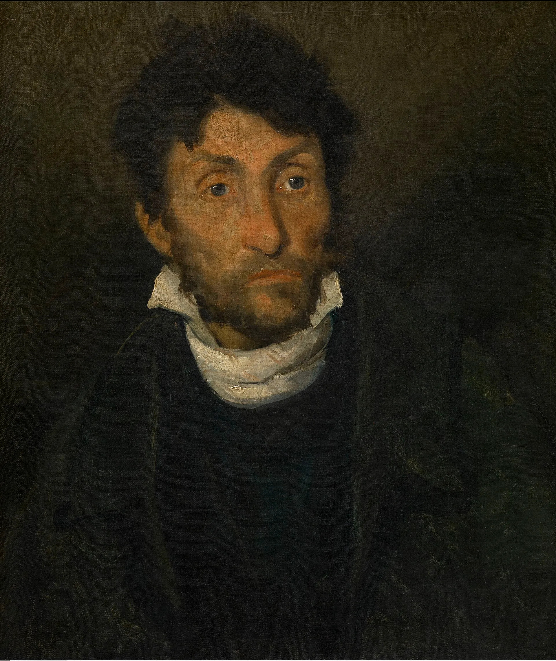 Portrait of a man with a distracted stare against a dark background.
