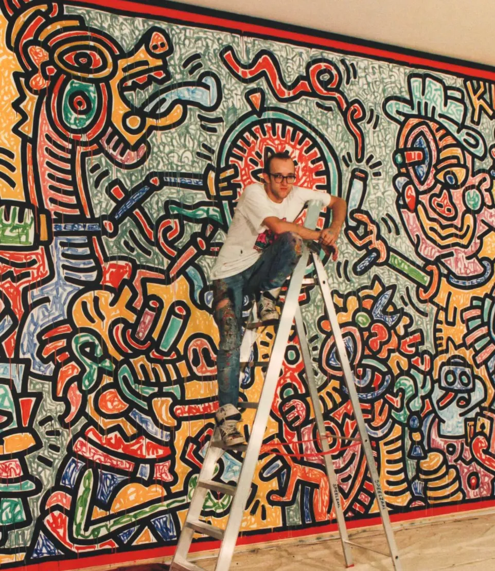 Keith Haring mural with black-outlined figures on a coloured ground.
